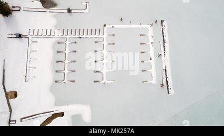 Tierspuren Kreuz das Eis um einen Bootssteg in den See eingefroren. Stockfoto