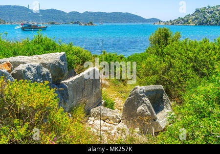 Die Ruinen der antiken lykischen Felsengräber von Kekova Nekropole, an der felsigen Küste, Üçagiz, Türkei. Stockfoto