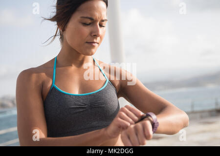 Die obere Hälfte der junge Brünette in Fitness top Ihr erobert mit der Sonne auf Ihre leuchtenden Stockfoto
