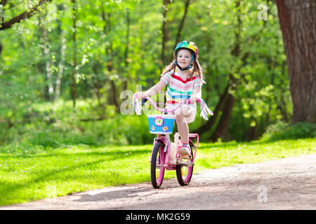 Kind Fahrrad fahren im Sommer Park. Kleines Mädchen lernen ein Fahrrad ohne Stützräder zu fahren. Kindergarten Kind auf zwei Wheeler Fahrrad. Aktive übertreffen Stockfoto