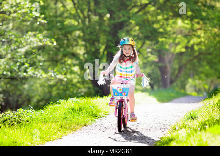 Kind Fahrrad fahren im Sommer Park. Kleines Mädchen lernen ein Fahrrad ohne Stützräder zu fahren. Kindergarten Kind auf zwei Wheeler Fahrrad. Aktive übertreffen Stockfoto