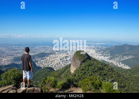 Ein Wanderer mit Blick auf die Skyline von Rio de Janeiro Tijuca Mirim Peak in den Wäldern von Tijuca Nationalpark Stockfoto