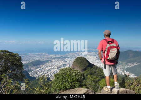 Ein Wanderer mit Blick auf die Skyline von Rio de Janeiro Tijuca Mirim Peak in den Wäldern von Tijuca Nationalpark Stockfoto