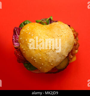 Herzförmige hamburger, liebe Burger fast food Konzept, auf rotem Hintergrund, Ansicht von oben Stockfoto