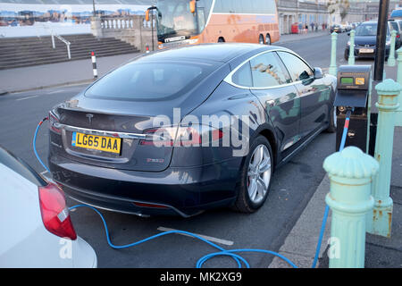 Brighton UK - Tesla-Auto wird am elektrischen Punkt an der Strandpromenade von Brighton aufgeladen Stockfoto