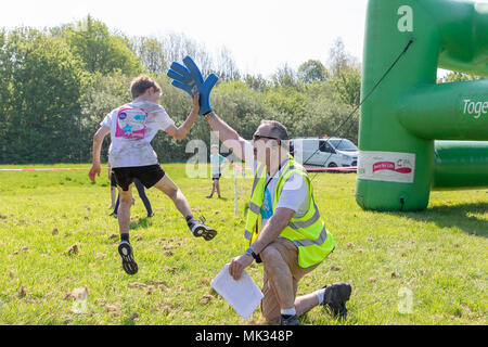 Warrington, UK, 6. Mai 2018. Sonnenschein und das Rennen für das Leben in Potsdam hat Hunderte von Menschen in Victoria Park in Warrington gebracht. Dies war das erste Jahr Kinder hatten ihre eigene ausführen und die Marschälle in der Unterhaltung. High Fives, um Credit: John Hopkins/Alamy leben Nachrichten Stockfoto