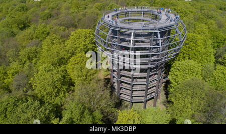 05 Mai 2018, Deutschland, Prora: Touristen sind auf der 40 m hohen Aussichtsplattform, das Herz des 1250 Meter langen treetop Walk. Der hölzerne Turm in der Form eines Horst umgibt eine Rotbuche und ist an den natürlichen Heritage Center in einem Buchenwald auf der Insel Rügen entfernt. Der Weg in den Turm geht bis 600 Meter und bietet einzigartige Einblicke in das Leben und die Entwicklung der Buche. Die Aussichtsplattform mit einer Gesamthöhe von 82 Metern über dem Meeresspiegel bietet einen weiten Blick über die Mecklenburger Landschaft. Das natürliche Erbe Zentrum wird von der über 1.900-ha-großen natürlichen herit umgeben Stockfoto