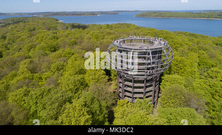 05 Mai 2018, Deutschland, Prora: Touristen sind auf der 40 m hohen Aussichtsplattform, das Herz des 1250 Meter langen treetop Walk. Der hölzerne Turm in der Form eines Horst umgibt eine Rotbuche und ist an den natürlichen Heritage Center in einem Buchenwald auf der Insel Rügen entfernt. Der Weg in den Turm geht bis 600 Meter und bietet einzigartige Einblicke in das Leben und die Entwicklung der Buche. Die Aussichtsplattform mit einer Gesamthöhe von 82 Metern über dem Meeresspiegel bietet einen weiten Blick über die Mecklenburger Landschaft. Das natürliche Erbe Zentrum wird von der über 1.900-ha-großen natürlichen herit umgeben Stockfoto