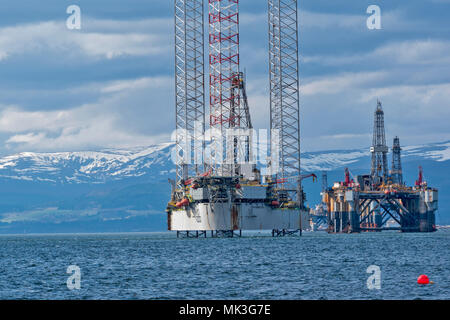 CROMARTY FIRTH SCHOTTLAND HOCH BOHRINSEL oder BOHRPLATTFORM BAUG UND STILLGELEGTEN ÖLPLATTFORM mit Schnee bedeckten Hügeln Stockfoto