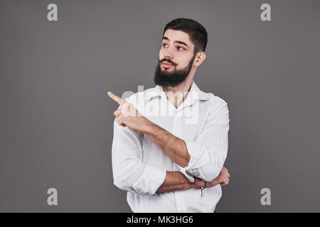 Fröhlicher schöner Mann, der die Richtung und zeigt mit dem Finger Stockfoto