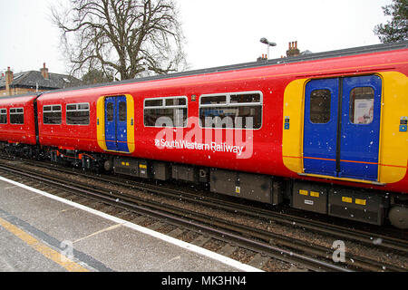 London, Großbritannien: 26. Februar 2018: a South Western Zug zieht in Teddington Bahnhof mit Schnee zu einer möglichen Unterbrechung zu reisen. Stockfoto