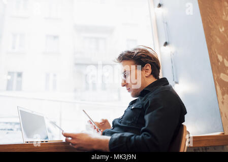 Entspannt Young Professional Surfen im Internet auf seinem Laptop in einem Café Stockfoto