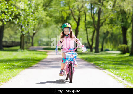 Kind Fahrrad fahren im Sommer Park. Kleines Mädchen lernen ein Fahrrad ohne Stützräder zu fahren. Kindergarten Kind auf zwei Wheeler Fahrrad. Aktive übertreffen Stockfoto