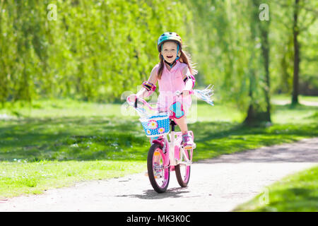 Kind Fahrrad fahren im Sommer Park. Kleines Mädchen lernen ein Fahrrad ohne Stützräder zu fahren. Kindergarten Kind auf zwei Wheeler Fahrrad. Aktive übertreffen Stockfoto