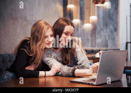 Zwei Mädchen im Netz surfen, auf soziale Netzwerke auf einem Laptop und Spaß haben Stockfoto