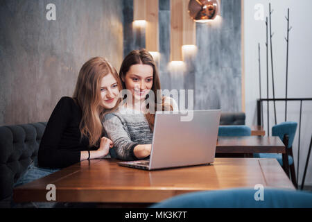 Zwei Mädchen im Netz surfen, auf soziale Netzwerke auf einem Laptop und Spaß haben Stockfoto