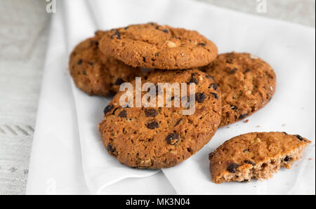 Auf dem Tisch liegt ein leckeres Plätzchen mit Schokoladenstückchen. Stockfoto