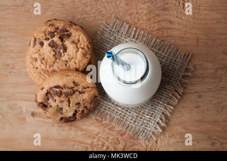 Mit Milch und Chocolate Chip Cookies auf dunklem Hintergrund Flasche. Ansicht von oben. Stockfoto