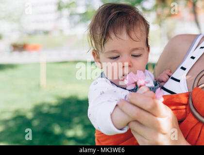 Mutter Kind Baby in wrap Schleuder in Park. Frühling. Konzept der natürlichen parenting glückliche Familie Frühling Konzept Stockfoto