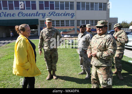 Kalifornien Nationalgarde Vertretern treffen mit einem eigenen Sicherheit sentry Nov. 1 an der Sonoma County Fairgrounds in Santa Rosa, Kalifornien, eine der wenigen verbliebenen Evakuierung Websites für Obdachlose Opfer nach dem Northern California wildfires verwendet. Angezeigt: Maj. Donald L. Lipscomb, Operations Officer, 579 Techniker Bataillon; Senior Master Sgt. Johnny Gatlin, Betriebsleiter, 146 Sicherheitskräfte Squadron; und 1 st. Sgt. Antonio M. Delgadillo, erste Sergeant für die 149 CBRN-Unternehmen. (Army National Guard Foto: Staff Sgt Eddie Siguenza) Stockfoto