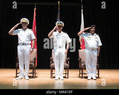 171102-N-XP 344-025 MANAMA, Bahrain (Nov. 2, 2017) Türkischen Seestreitkräfte hinten Adm. Emre Sezenler, ausgehende Kommandant der kombiniert maritimen Kräfte' (CMF) kombinierte Task Force (CTF) 151, Links, U.S. Navy Vice Adm. John aquilino, Kommandeur der CMF, Mitte, und eingehende CTF151 Commander, Royal Bahrain Navy Capt. Yusuf Almannaei, rechts, Salute während der Task force Ändern des Befehls Zeremonie am Naval Support Activity Bahrain. Das CTF151 Mission ist Piraterie auf See zu stören und zu engagieren, mit regionalen und anderen Partnern den Aufbau von Kapazitäten und Fähigkeiten verbessern, um die globale Ma zu schützen. Stockfoto