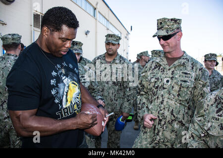 171102-N-NT 795-396 Imperial Beach, Calif (2. November 2017) Herschel Walker, Heisman Trophy Sieger, professioneller Athlet, Geschäftsmann und Autor, einen Fußball für Cmdr. James W. Hendley, Logistics Officer von Coastal Riverine Group (CRG) 1 Bei seinem Besuch an Bord Imperial Beach Naval Outlying Landeplatz zugeordnet. Walker stellt Service Mitglieder, Veteranen und militärische Familien emotionale und motivationale Unterstützung durch Vorträge auf militärische Einrichtungen im ganzen Land. (U.S. Marine Foto von Chief's Bootsmann Mate Nelson Doromal/Freigegeben) Stockfoto