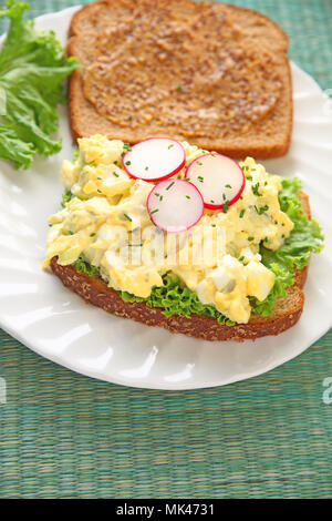 Cremige ei Salat mit Radieschen und Schnittlauch auf Vollkornbrot mit deli Senf Stockfoto