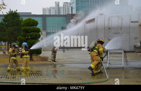 Us Air Force Feuerwehrmänner Osan Flughafen und lokalen Koreanischen Feuerwehrmänner zugewiesen, um gemeinsam eine simulierte Flugzeug Feuer während eines bilateralen, Masse- und Unfallversicherung zu löschen, Not-services Übung an Kookje College, der Republik Korea, November 2, 2017. Der 51 Bauingenieur Squadron Feuerwehr- und Rettungsdienste pflegen gegenseitige Hilfsabkommen mit den umliegenden lokalen Feuerwehren die Sicherheit der einheimischen Bevölkerung und Personal auf und weg von der Unterseite zu gewährleisten. Diese Arten von Übungen der Bereitschaft und Funktionsunfähigkeit der Schutz sorgen. (U.S. Air Force Foto: Staff Sgt. Alex Stockfoto