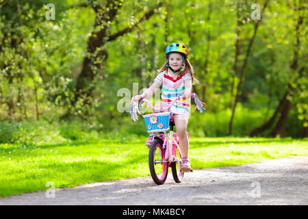 Kind Fahrrad fahren im Sommer Park. Kleines Mädchen lernen ein Fahrrad ohne Stützräder zu fahren. Kindergarten Kind auf zwei Wheeler Fahrrad. Aktive übertreffen Stockfoto