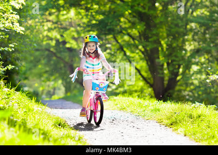 Kind Fahrrad fahren im Sommer Park. Kleines Mädchen lernen ein Fahrrad ohne Stützräder zu fahren. Kindergarten Kind auf zwei Wheeler Fahrrad. Aktive übertreffen Stockfoto