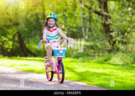 Kind Fahrrad fahren im Sommer Park. Kleines Mädchen lernen ein Fahrrad ohne Stützräder zu fahren. Kindergarten Kind auf zwei Wheeler Fahrrad. Aktive übertreffen Stockfoto