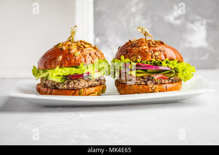 Vegan bean Burger mit Gemüse und Tomatensauce auf weißem Teller, kopieren. Gesunde vegane Ernährung Konzept. Stockfoto