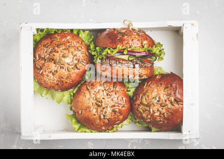 Vegan bean Burger mit Gemüse und Tomatensauce in weißen Holzkasten, Ansicht von oben. Gesunde vegane Ernährung Konzept. Stockfoto