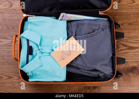 Koffer mit ordentlich gefaltete Kleidung. Karte und Post mit Briefmarken. Stockfoto