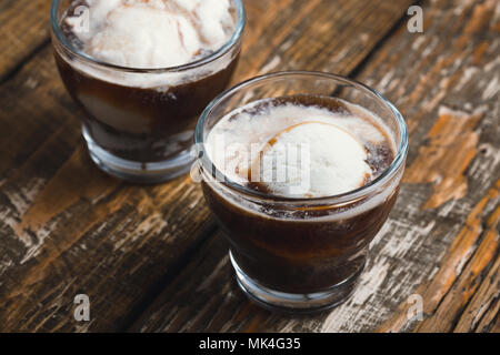 Kalter Kaffee brühen mit Eis im Glas auf Holz rustikal Tisch, köstlichen Sommer Dessert Stockfoto