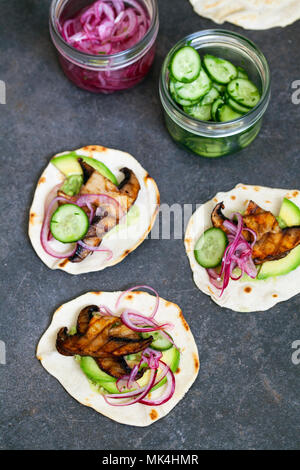 Veganen Tortillas mit Pilzen, Avocado, eingelegte Zwiebeln und Gurken Stockfoto