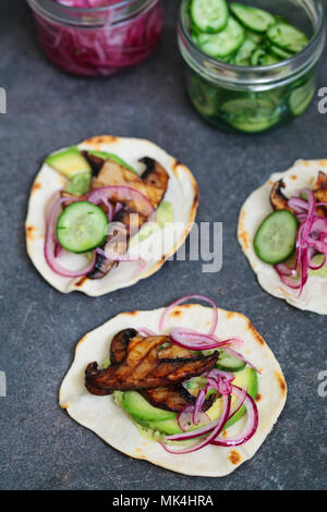 Veganen Tortillas mit Pilzen, Avocado, eingelegte Zwiebeln und Gurken Stockfoto