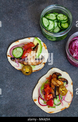 Veganen Tortillas mit Pilzen, Avocado, eingelegte Zwiebeln und Gurken Stockfoto