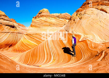Männliche Wanderer in der Welle, bunten Sandstein Bildung, North Coyote Buttes, Vermilion Cliffs National Monument Arizona USA. Stockfoto