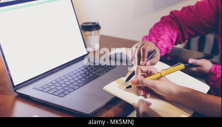 Asiatische Geschäftsfrauen Holding einen Stift und Analyse von Dokumenten auf Office Tabelle mit Laptop und Grafik Die Grafik im Hintergrund arbeiten Stockfoto