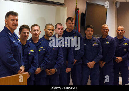 Vice Adm. Karl Schultz, Coast Guard Atlantischen Gebiet Commander, präsentiert 12 Küstenwache für die Maritime Security Response Team mit der Marine Combat Action Ribbon in Chesapeake, Va., Nov. 8, 2017 zugeordnet. Die Verleihung des Combat Action Ribbon an die Crew der USS Mason und Küstenwache waren an Bord zum ersten Mal in der mehr als 25 Jahre die Marine hat offiziell anerkannten Besatzung eines Schiffes ein Meer für unter feindliches Feuer. U.S. Coast Guard Foto von Petty Officer 2. Klasse Adam Stanton. Stockfoto