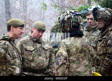 Trotz Schnee, Brig. Gen. Zac Stenning (LFT), Commander, 1. mechanisierten Brigade der Britischen Armee, Haltestellen von mit britischen Soldaten mit der 1 Bataillon, Royal Regiment der Füsiliere Ausbildung bei der US Army Joint Multinational Readiness Center in Hohenfels, Deutschland zu besuchen, da sie in Alliierten Geist VII, 12 Nov. 2017 teilnehmen. Etwa 4.050 Mitglieder aus 13 Nationen nehmen an der übung Allied Geist VII 7th Army Training Befehl des Truppenübungsplatzes Hohenfels, Deutschland, Okt. 30 bis Nov. 22, 2017. Allied Geist ist ein US-Army Europe, 7 ATC-Multinatio durchgeführt. Stockfoto