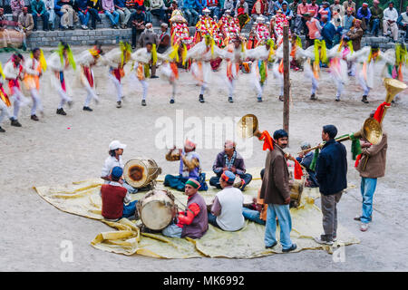 Naggar, Himachal Pradesh, Indien: Während der naggar Mela festival Musiker sitzen auf dem Boden, während hohe Kaste rajputen Tanz in einem Kreis auf. Stockfoto