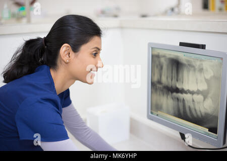 Closeup Portrait von Alliierten zahnmedizinische Heilberufe in blau scheuert Prüfung Zahnröntgen auf Bildschirm, isolierte Zahnarztpraxis Stockfoto