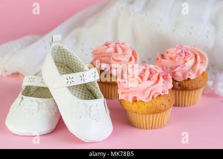 Taufe oder Geburtstag Einladung Mädchen mit rosa Cup Cakes und weiße Schuhe auf rosa Hintergrund Stockfoto