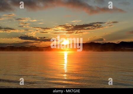 Sonnenaufgang am Yellowstone Lake - ein Ende August Morgen, die Sonne über dem Nebel Yellowstone Lake, Yellowstone National Park, Wyoming, USA. Stockfoto