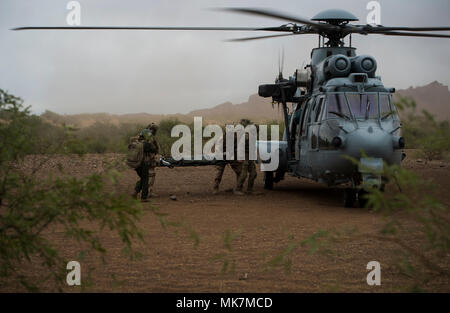 Ein US Air Force pararescuemen zugeordnet. bis 48 Rescue Squadron und französische Air Commandos einen simulierten Patienten zu einem Eurocopter EC-725 für Antenne Transport bewegen sich bei einem Personal recovery Szenario im südlichen Arizona an November 7, 2017. Engel Thunder ist eine zweiwöchige, Air Combat Command-gefördert, gemeinsame zertifizierte und akkreditierte Personal Recovery Übung konzentriert sich auf die Suche und Rettung. Die Übung ist so konzipiert, Ausbildungsmaßnahmen für das Personal recovery Vermögenswerte mit einer Vielzahl von Szenarien zu simulieren, Bereitstellung von Bedingungen und Möglichkeiten zu bieten. (U.S. Air Force Foto: Staff Sgt. Andrew Lee) Stockfoto