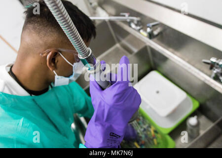 Pfc. Claude Daniel, eine Armee finden Zahntechniker, Scrubs zahnmedizinische Instrumente vor der Sterilisation in der Betreuung Hafen, in Los Angeles, Calif., Nov. 18, 2017. Daniel ist eines von Dutzenden von Soldaten aus der 7214Th Medical Support Unit, in Los Alamitos, Calif., die freiwillig helfen medizinische Dienstleistungen für die Bürger von Los Angeles bieten stationiert, von denen viele nicht die medizinische Versorgung erhalten haben. (U.S. Armee Foto: Staff Sgt. Felix R. Fimbres) Stockfoto