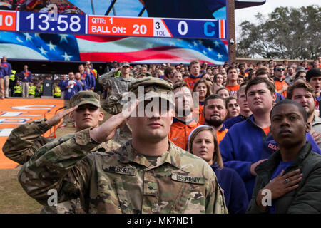 Clemson Armee ROTC Kadetten salute während der Nationalhymne vor der Clemson Universität der jährlichen militärischen Anerkennung Tag November 18, 2017 at Memorial Stadium während der abschließenden Heimspiel gegen die Zitadelle. (U.S. Army National Guard Foto: Staff Sgt. Erica Ritter, 108 Öffentliche Angelegenheiten Abteilung) Stockfoto