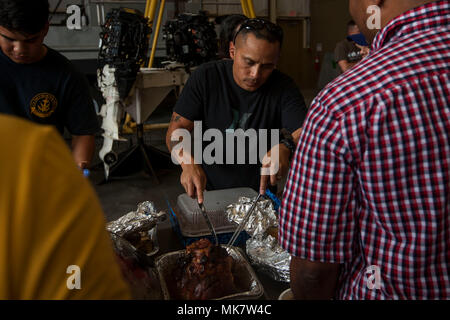 Sgt. Maj. Phillip Billiot, das Bataillon Sergeant Major der Zentrale Bataillon, Marine Corps Base Hawaii (MCBH), Schnitte und dient der Türkei während potluck Ereignis der Einheit im Waterfront Operationen, MCBH, Nov. 17, 2017. Die "Potluck" ist eine von vielen Veranstaltungen des Bataillons, die Mitarbeiter und ihre Familien zusammen zu bringen Einheit Kameradschaft zu errichten. (U.S. Marine Corps Foto von Lance Cpl. Isabelo Tabanguil) Stockfoto